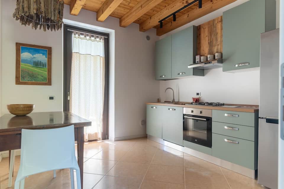 Cucina di Margherita House con soffitto in legno e accesso all’esterno